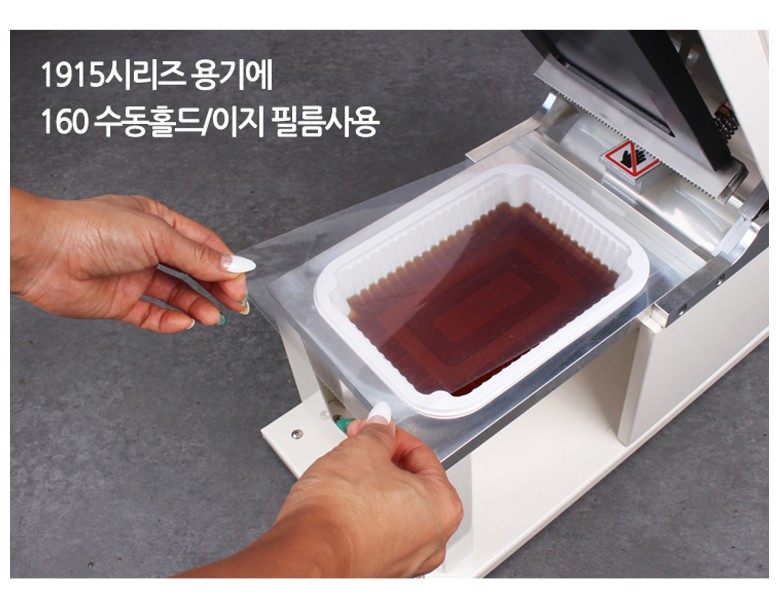 실링기계에 용기를 놓고, 수동이지필름으로 실링하려는 이미지