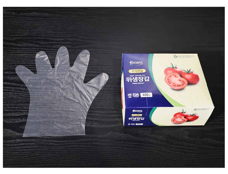 투명한 위생장갑 한 장이 검은 테이블 위에 펼쳐져 비닐장갑의 전체 크기와 손가락 형태가 잘 드러남
