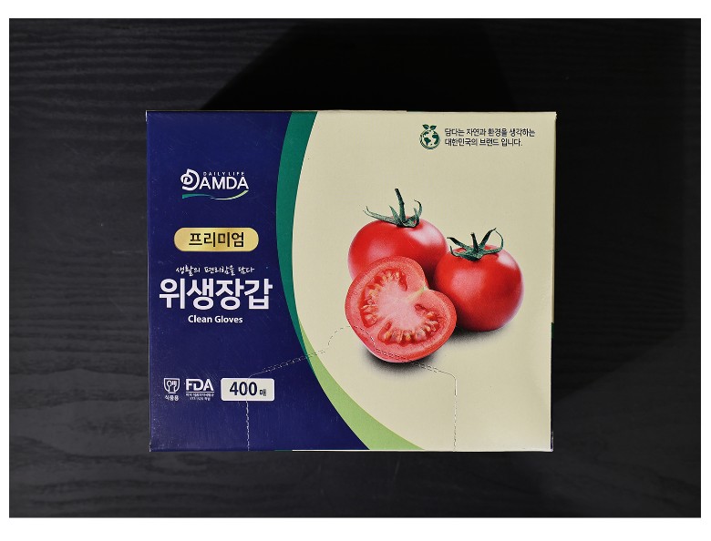 토마토 이미지를 활용한 패키지 디자인이 돋보이며, 위생장갑 제품명이 깔끔하게 인쇄된 모습