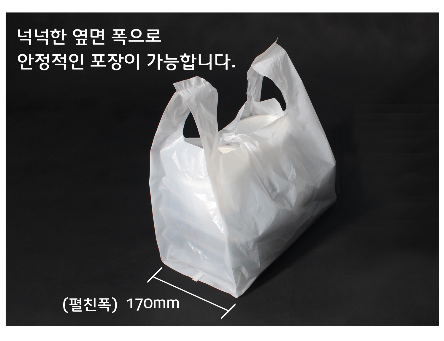 검은색 바탕에 비닐봉투가 물건이 담겨 놓여있다.
옆면 폭이 넓어 포장이 안정적으로 포장된 모습이다.