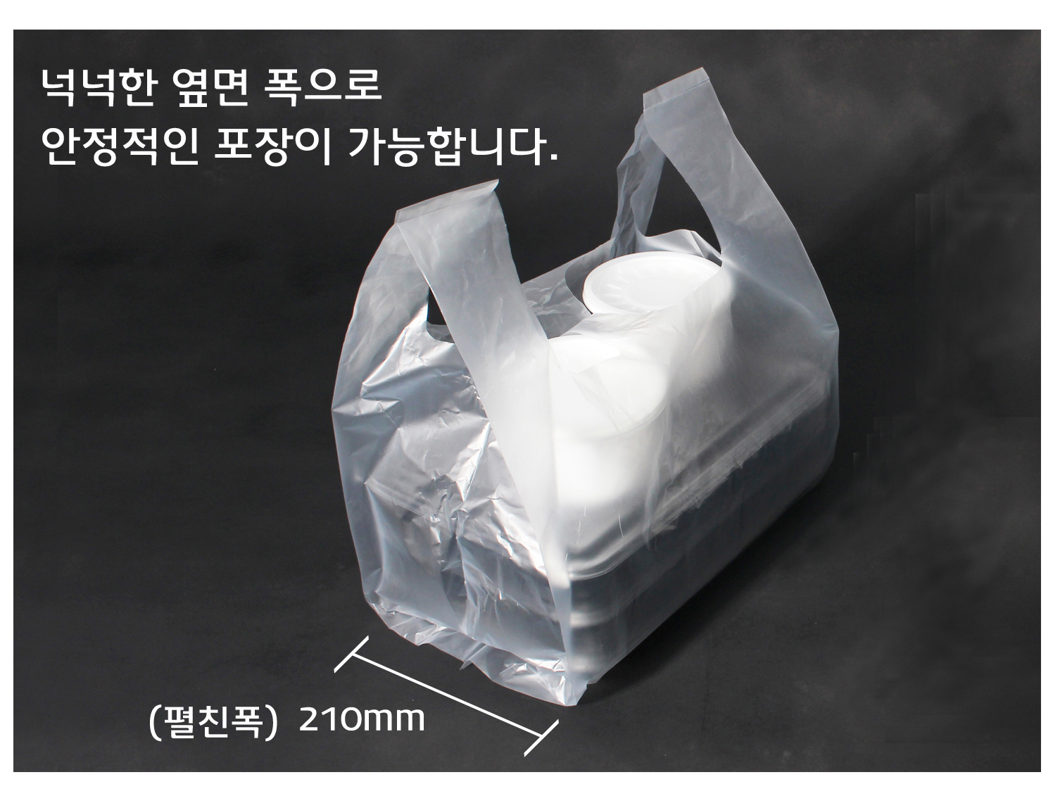 검은색 바탕에 비닐봉투가 물건이 담겨 놓여있다.
옆면 폭이 넓어 포장이 안정적으로 포장된 모습이다.